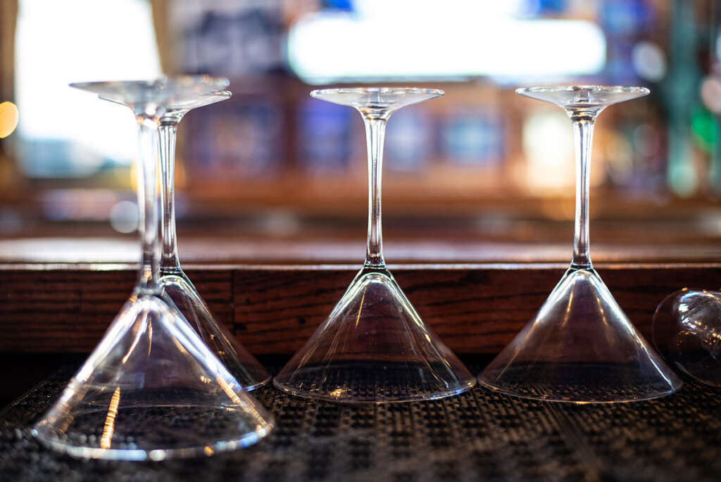 Martini glasses on the bar rail at Hattricks