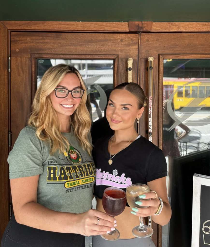 Two of the staff outside Hattricks with a red and a white wine